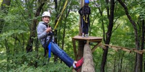 boy giving thumbs up on high ropes course